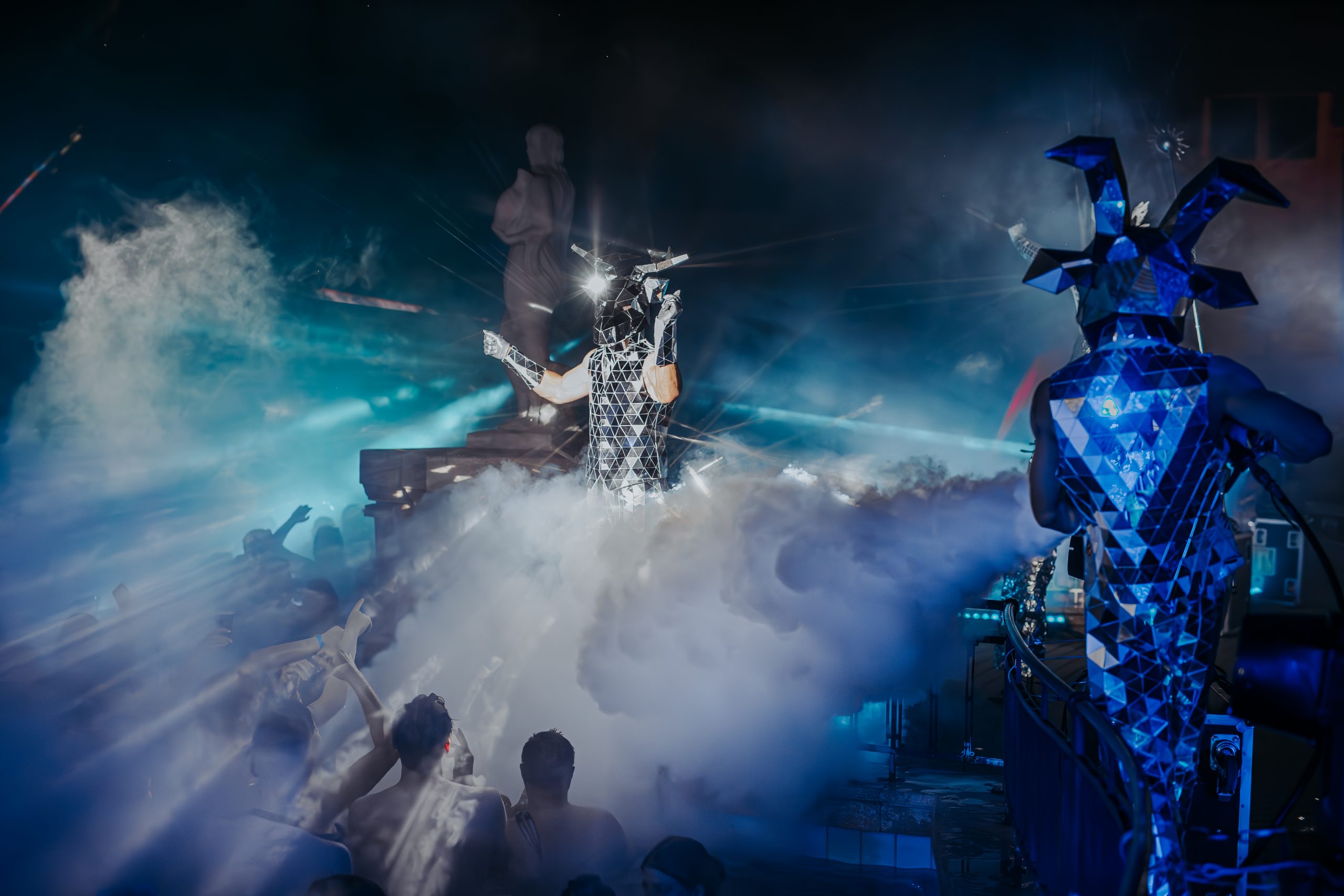 Performers in mirrored costumes above the steam at Sparty
